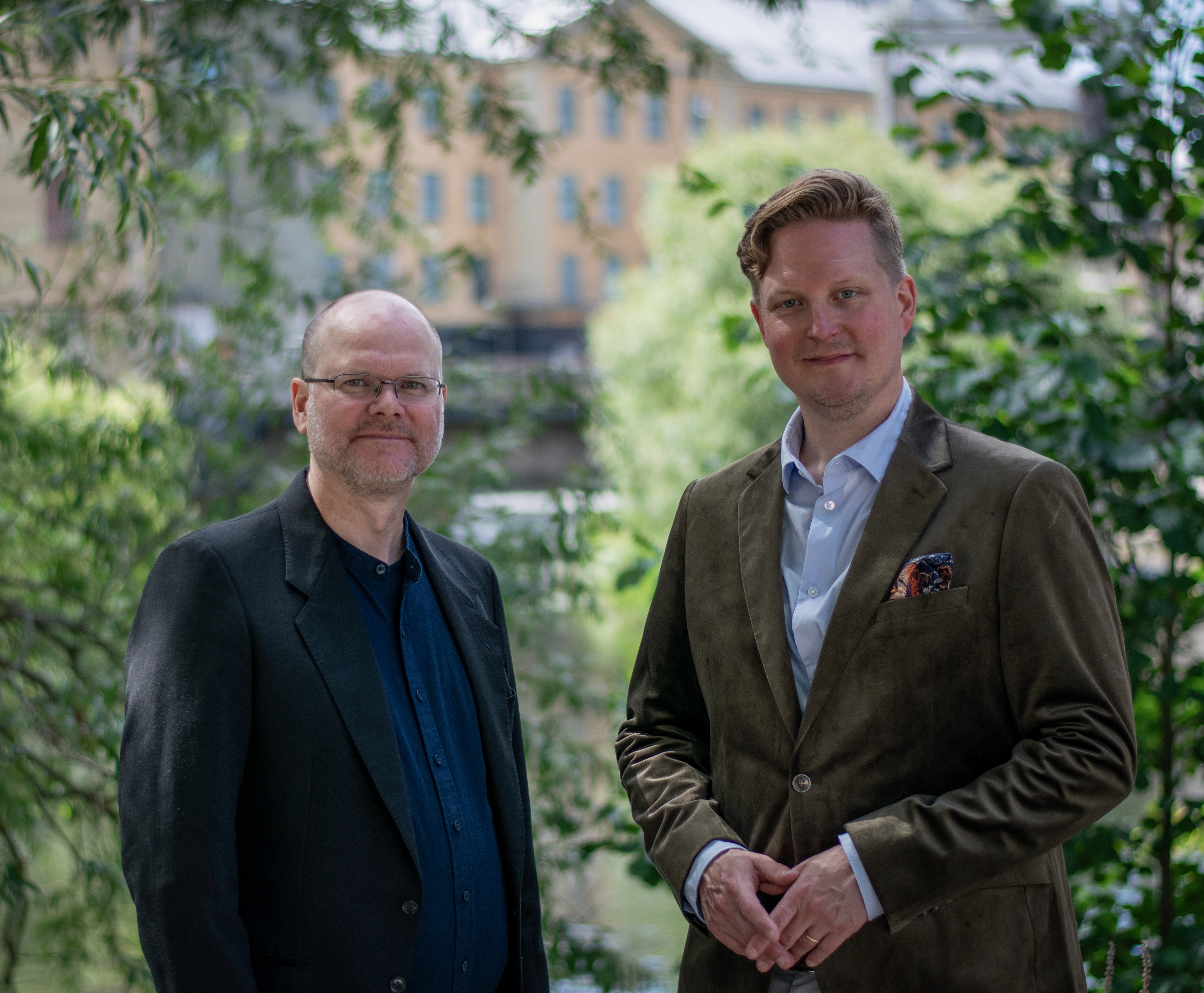 Duo framför grönskande bakgrund vid vattnet